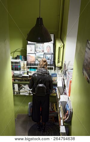 ST. PETERSBURG, RUSSIA - OCTOBER 12, 2018: Girl reading a magazine in a book store. Saint Petersburg has twice more book shops per inhabitant that any other city of Russia