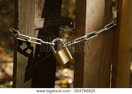 Wooden gate locked by a padlock and chain