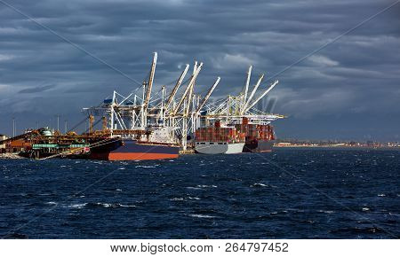 Ships Under Loading In The Seaport In The City Of Tsawwassen, Stormy Sea Dramatic Sky, Overcast.