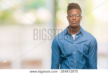 Young african american man over isolated background with serious expression on face. Simple and natural looking at the camera.