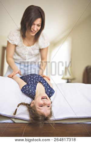 Mother Playing With Her Baby In The Bedroom