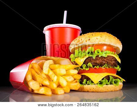 Tasty hamburger and french fries on a dark background