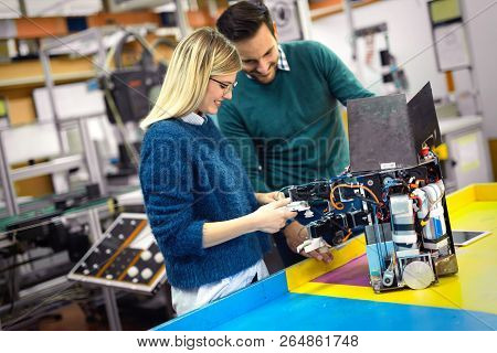 Young Attractive Students Of Mechatronics Working On Project