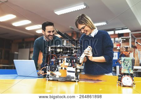 Young Attractive Students Of Mechatronics Working On Project
