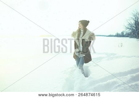 Winter Sport Activity. Woman Hiker Hiking With Backpack And Snowshoes Snowshoeing On Snow Trail Fore