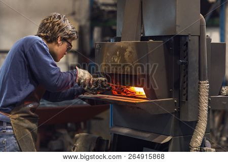 Young Blaksmith Working In A Metalworking Workshop