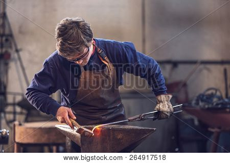 Young Blacksmith Working With Red Hot Metal