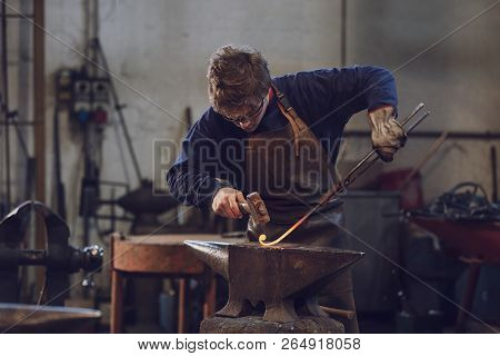 Young Blacksmith Working With Red Hot Metal