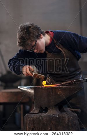 Young Blacksmith Working With Red Hot Metal