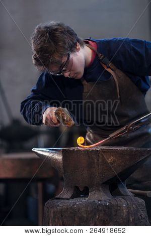 Young Blacksmith Working With Red Hot Metal