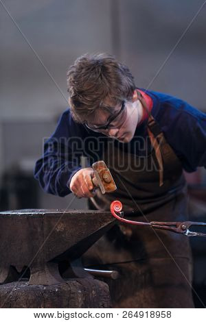 Young Blacksmith Working With Red Hot Metal