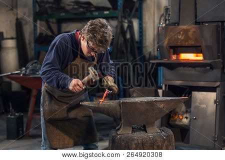 Young Blacksmith Working With Red Hot Metal