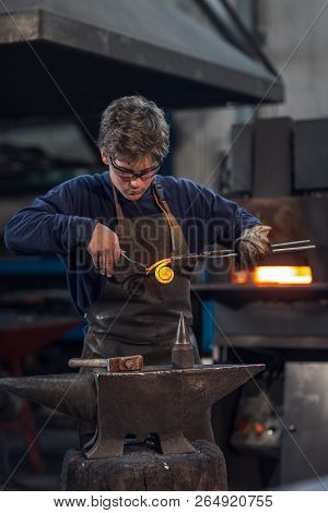 Young Blacksmith Working With Red Hot Metal