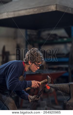 Young Blacksmith Working With Red Hot Metal
