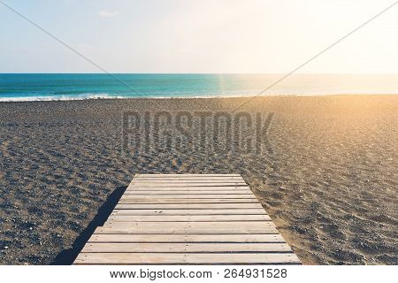 Wooden Gangplank On Beach Against Sea And Blue Sky On Sunny Day