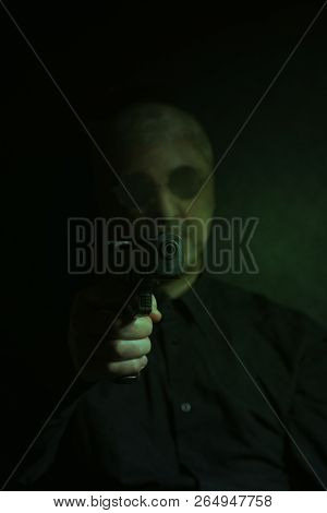 Criminal Bandit Man Wearing A Stocking Mask Holds A Gun On Black Background