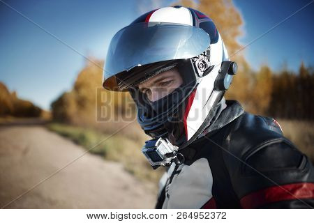 Biker In A Helmet Looking Away In Nature