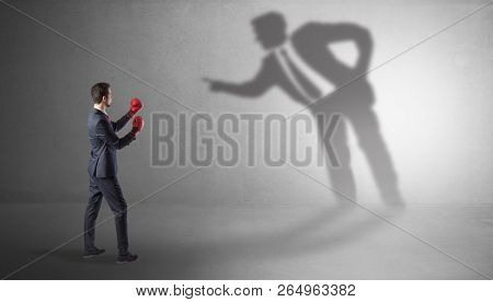 Businessman fighting with his bossy yelling shadow