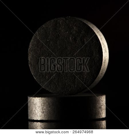 Medical Drug, Black Tablet Activated Carbon On A Black Background In Backlight