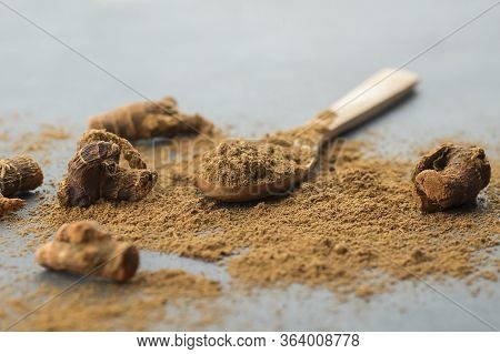 Galangal Root And Galanga Powder In Wooden Spoon On Rustic Table. Healthy Spice Concept (alpinia Off