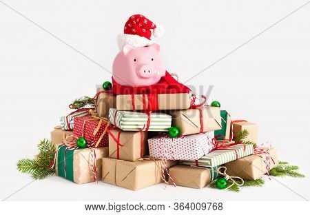 Piggy Bank In Santa Claus Hat. Christmas Gift Boxes. White Background. The Concept Of Saving.