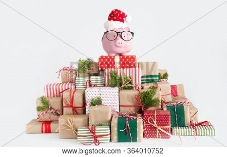 Piggy Bank In Santa Claus Hat. Christmas Gift Boxes. White Background. The Concept Of Saving.