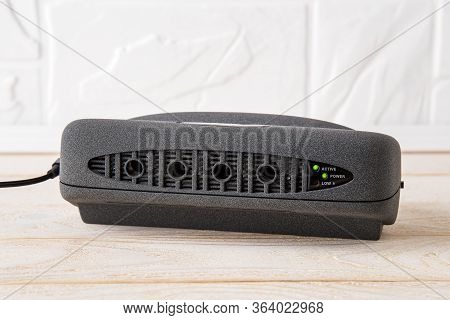Black Air Ionizer On A White Wooden Table. Air Purifier With Anion Generator For Fresh Air And Remov