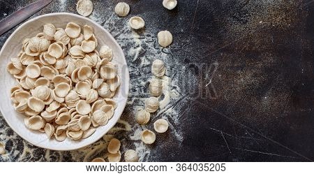 Fresh Raw Apulian Pasta Orecchiette Made From Whole Wheat Flour On A Dark Table Top View