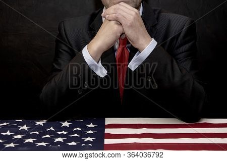 The Man Was Leaning Over A Coffin Covered In An American Flag, His Hands Clasped Over His Face. He M