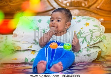 A Asian Baby Boy Is Looking And Playing At Colorful Toys.