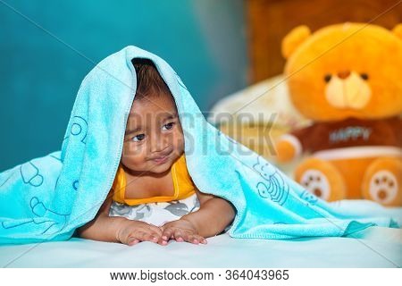 A Six Months Age Asian Baby Boy Playing A Yellow Taddy Bear.