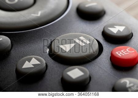 A Macro Portrait Of The Play And Payse Button On A Television Remote Control. The Button Is Surround