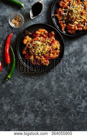 Asian Chicken In Sweet And Sour Sauce On Plate Over Dark Stone Background With Free Text Space. Spic