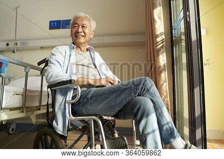 Asian Old Man Sitting In Wheel Chair In Nursing Home Or Hospital Ward Looking Happy And Content
