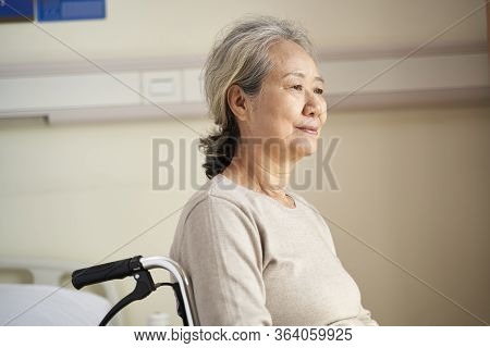 Content Asian Elderly Woman Sitting In Wheelchair In Her Room In Nursing Home With Peaceful Facial E