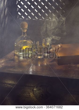 Close Up View Of Bottle Of Tequila Anejo And Cigar On Color Background