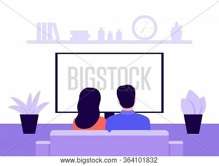 Family Young Couple Man And Woman Sitting On Sofa At Home And Watching Tv, Back View. Living Room In