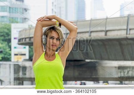 Woman In Sport Wear  Doing Stretching Exercise And Listening Music.concept Of Healthy, Fitness, Spor