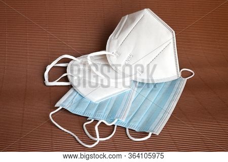 Detail Of A Group Of Ffp2 And Surgical Protective Masks On A Brown Background. Covid19 Or Coronaviru