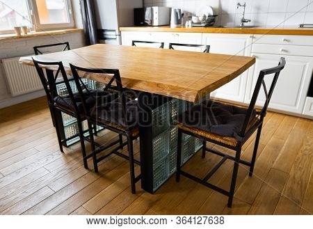A Big Wooden Dining Table With Glass Blocks And Metal Wicker Chairs And Pillows In Modern Scandinavi