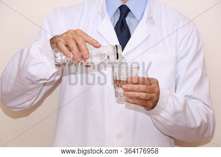 The Doctor Pours A Glass Of Useful Mineral Water For Diet