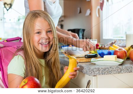 Aile - sabah ve bir aperatif okul çocukları için kahvaltı yapmak anne