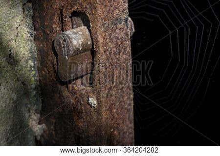 Rusty Lock And An Outdated Keyhole On A Rusted And Abandoned Gate In A Dark Room With A Spider Web I