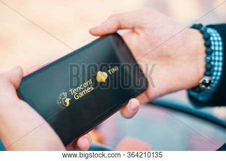 Bishkek, Kyrgyzstan - October 4, 2019: Man Holding Smartphone With Logo Of Tencent Games And Timi On