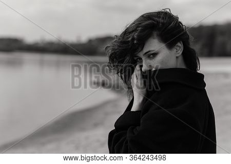 Curly Woman Looking Out Of The Coat Collar