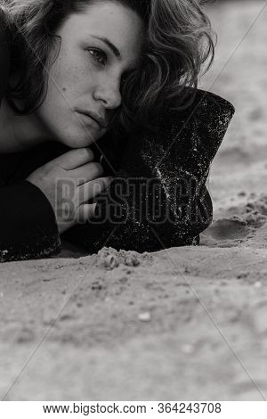 Close Up Portrait Of The Woman On The Sand Looking Up