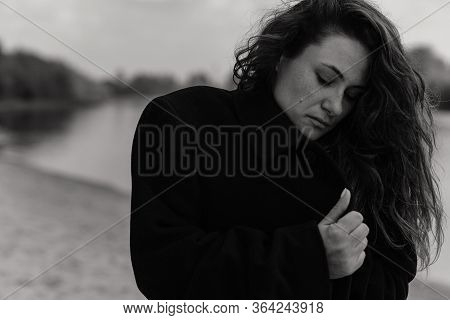 Woman Looking Down And Holding Her Coat Collar