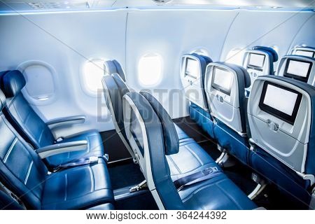 Interior of an empty airplane. View from the back of the plane. Nobody on the plane. Abstract air travel photo.