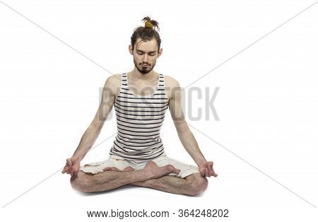 Yoga Guy With Closed Eyes Sits In Lotus Position. White Background In The Studio. Meditation. Stress