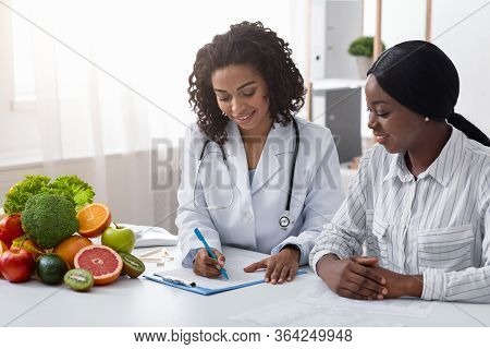 African American Woman Dietologist Taking Female Patient Anamnesis, Nutritionist Consultation, Copy 